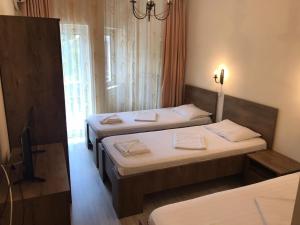 a room with two beds and a tv in it at Pensiunea Paradis in Băile Herculane