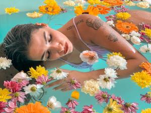a woman laying in a pool of flowers at Playa del Mar - Adults Only in Monopoli