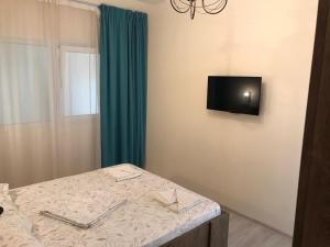 a room with a table and a tv on the wall at Pensiunea Paradis in Băile Herculane