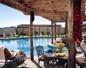 a patio with a table and chairs next to a pool at Lajitas Golf Resort in Terlingua