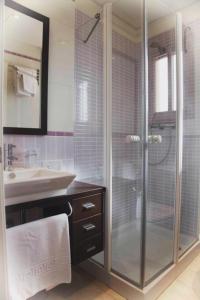 a bathroom with a glass shower and a sink at Colores de Zahara in Zahara de los Atunes
