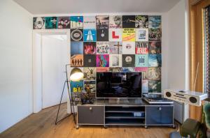 um quarto com televisão e uma parede com cartazes em Salis 06 by Arosa Holiday em Arosa