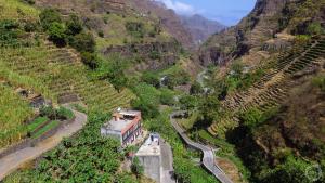 an aerial view of a mountain with a house and a road at casa xoxo in Ribeira Grande