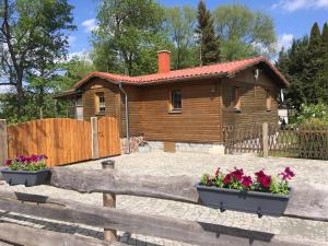 una cabaña de madera con dos macetas de flores delante de ella en CS-Ranchhaus, en Hörselberg-Hainich