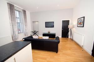 a living room with a black couch and a tv at Parkhill Luxury Serviced Apartments - City Centre Apartments in Aberdeen