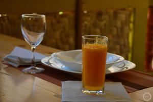 a glass of orange juice sitting next to a wine glass at casa xoxo in Ribeira Grande
