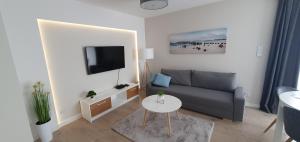 a living room with a couch and a table at Resort Apartamenty Klifowa Rewal 33 in Rewal