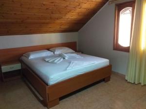 a bedroom with a bed with white sheets and two pillows at Hotel Central in Tirana