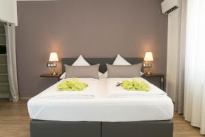 1 cama blanca grande con 2 almohadas amarillas. en CityApartment K1 KLIMATISIERT en Friedrichshafen