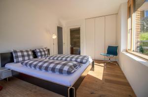 a bedroom with a bed and a chair in it at Salis 06 by Arosa Holiday in Arosa