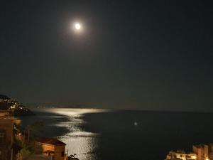 a full moon over a body of water at night at Villa Celentano in Positano