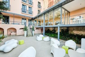 a courtyard with white chairs and a building at Sintra Bliss Hotel in Sintra