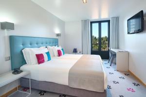 a hotel room with a large bed and a television at Sintra Bliss Hotel in Sintra