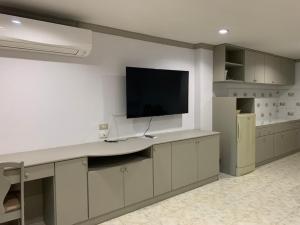 a kitchen with a desk with a tv on the wall at Blue Garden Resort Pattaya in Jomtien Beach