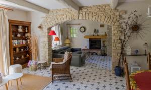 a living room with a stone archway at Maison de campagne au charme provençal in Saint-Rémy-de-Provence