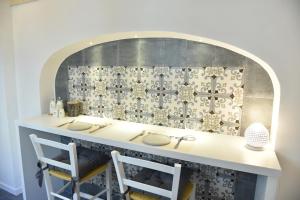 cocina con encimera con 2 sillas y pared en Tobacco Suite, en Mesagne