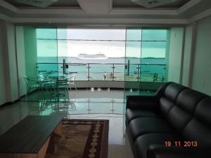 uma sala de estar com uma mesa de vidro e um navio de cruzeiro em Tapajós Center Hotel em Santarém