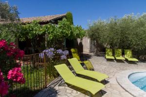 a group of yellow chairs next to a swimming pool at Maison de campagne au charme provençal in Saint-Rémy-de-Provence