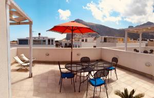 a patio with a table and chairs and an umbrella at Appartamento Il Pomodoro in San Vito lo Capo