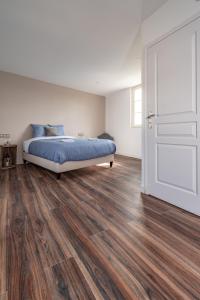 a bedroom with a bed and a wooden floor at L'Auberge du Croissant in Rochecorbon