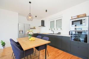 a kitchen with a wooden table and blue chairs at Villa Edita in Makarska