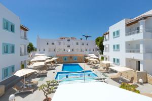 een resort met een zwembad en enkele witte gebouwen bij Apartamentos Los Arcos in Santa Eularia des Riu