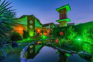 福塔莱萨神龙汽车旅馆(仅成人)的一座前面有池塘的大房子