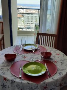 カネ・アン・ルシヨンにあるStudio Sympaの緑皿とワイングラスを用意したテーブル