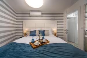 a bedroom with a large bed with blue and gray stripes at Forever apartment & rooms in Rijeka