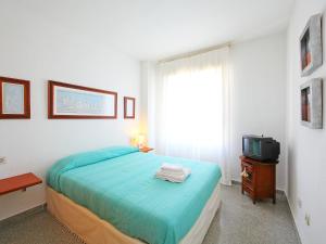 ein Schlafzimmer mit einem Bett, einem Fernseher und einem Fenster in der Unterkunft Apartment Cabo Mar by Interhome in El Campello