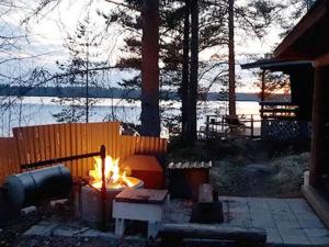 a fire pit in a yard next to a fence at Holiday Home Lähesniemi by Interhome in Hokkanen