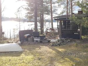 a small cabin with a lake in the background at Holiday Home Lähesniemi by Interhome in Hokkanen