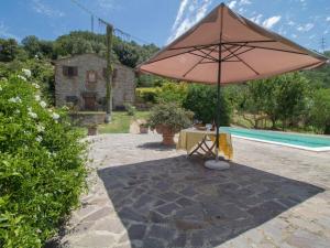 einen Tisch mit einem Sonnenschirm neben einem Pool in der Unterkunft Holiday Home I Casali Del Re by Interhome in San Vito