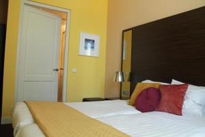 a bedroom with a large bed with a wooden headboard at Hotel De Villa in Dongen