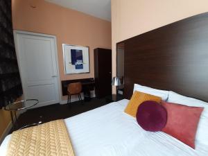 a bedroom with a large bed with a wooden headboard at Hotel De Villa in Dongen