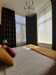 a bedroom with a large bed and two windows at Hotel De Villa in Dongen +31 photos