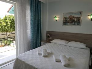 a bedroom with a white bed with towels on it at Hotel Mico in Dalyan