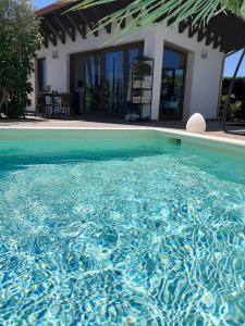 a swimming pool with blue water in front of a house at Villetta Del Salento Exclusive B&B in Gallipoli