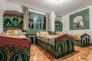 a bedroom with two beds and a mirror at Hotel Madrid in Chefchaouen