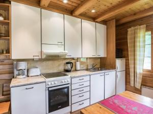 una cocina con armarios blancos y electrodomésticos blancos en Holiday Home Merenneito by Interhome, en Heinjoki