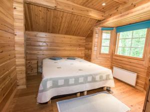 1 dormitorio con 1 cama en una cabaña de madera en Holiday Home Merenneito by Interhome, en Heinjoki
