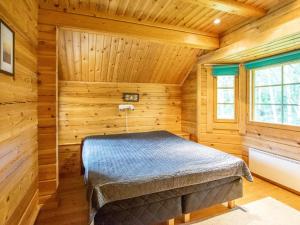 - une chambre avec un lit dans une pièce en bois dans l'établissement Holiday Home Meritähti by Interhome, à Heinjoki