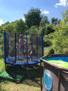 twee kinderen spelen op een trampoline bij Teremok Guest House in Vyshka