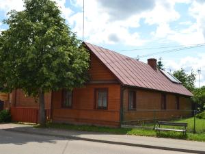 een houten huis met een bank ervoor bij Holiday Home Stoczek by Interhome in Białowieża
