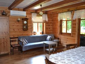 een woonkamer met een blauwe bank en tafels bij Holiday Home Stoczek by Interhome in Białowieża