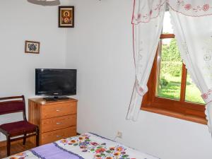 een slaapkamer met een bed, een tv en een raam bij Holiday Home Stoczek by Interhome in Białowieża