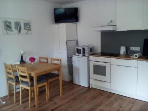 a small kitchen with a table and a microwave at Gästehaus Fechheim in Neustadt bei Coburg