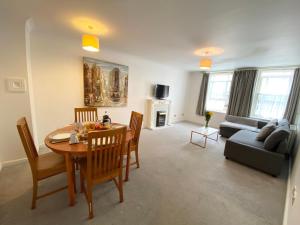 a living room with a table and chairs and a couch at Apartment next to Victoria Station in London