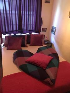 フォニョードにあるMG Apartmanházのベッドルーム1室(赤い枕のベッド2台付)