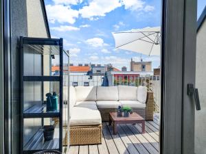 a couch sitting on a balcony with an umbrella at Boutique Design-Apartments Vienna in Vienna